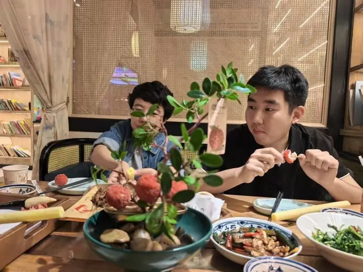 游客在西安一家餐厅品尝以“一骑红尘妃子笑，无人知是荔枝来”为灵感开发的陕菜新品“妃子笑”（2026年5月26日摄）。新华社记者张京品摄